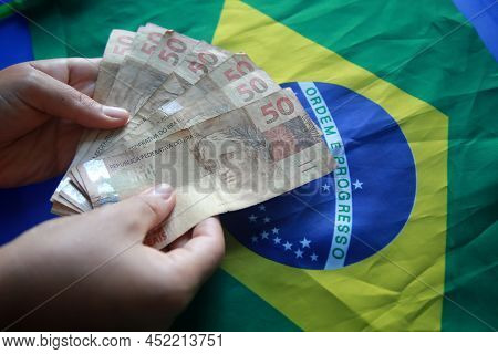 Brazilian Money Next To A Flag
