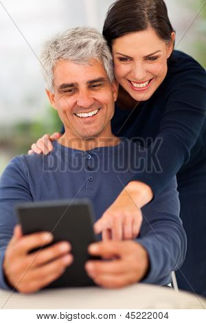 feliz pareja senior con tablet PC en casa
