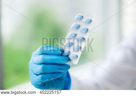 Closeup Of Female Doctor Holding Pill For Men Health