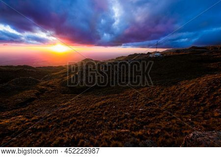 Purple Sunset With Green Mountains And Clouds