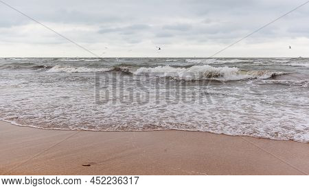 Huge Waves Raging In The Sea And Seagulls In The Spray Of Waves. Storm At Sea. Birds Fly Over The Wa
