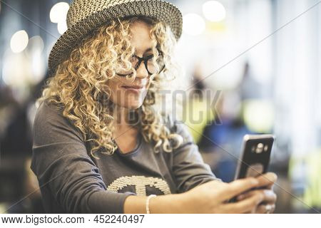 Adult Pretty Woman Smile And Use Mobile Phone To Chat And Sending Message. Modern Female People With