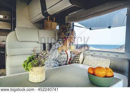 People And Alternative Vanlife Lifestyle Concept. Adult Woman Drinking And Enjoying Sea View Inside 