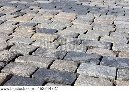 Stone Pavement Texture, Cobbled Street In Sunlight. Old Paved Road With Tiles From Cobblestones