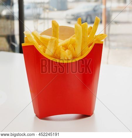 French Fries In A Red Box Are On The Table In A Restaurant.