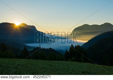Low Clouds As Dawn Breaks Over Sauris Valley Near The Alpine Village Of Sauris Di Sopra, Udine Provi