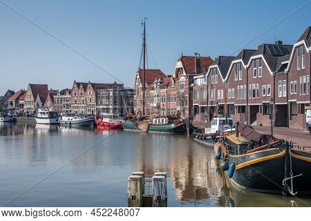 Hoorn, Netherlands, March 2022. The Harbor Of Hoorn With The Old Boats And Historic Facades.