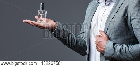 Man In Formal Suit, Bottle Of Perfume, Closeup. Fragrance Smell. Men Perfumes. Fashion Cologne Bottl