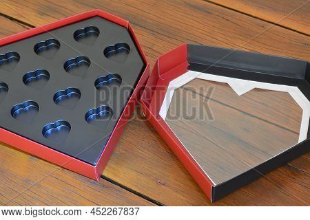 Gift Box. Open Heart-shaped Paper Box In Black Plastic With Aged Wooden Base, Red And Black Box, Bra