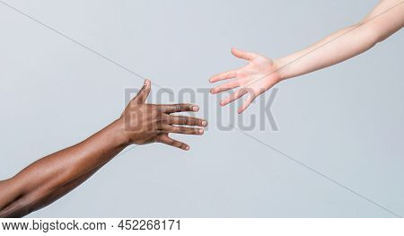 Giving A Helping Hand To Another. Woman And African Woman Hand. Helping Hand, Rescue, Multiathnic Pe