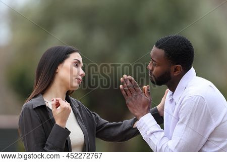 Regretful Man Asking Forgive To A Woman In A Park