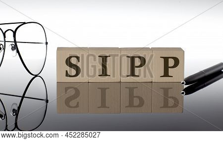 Close-up Of Sipp Wooden Blocks On Black Background With Glasses And Pen