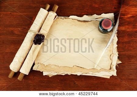 Papel velho, tinta, pergaminhos e penas no fundo de madeira