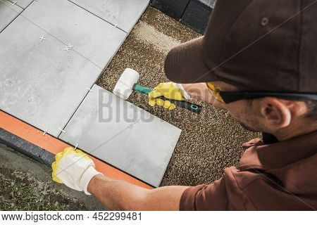 Professional Caucasian Worker In His 40s Building Concrete Bricks Path Inside Residential Garden. In