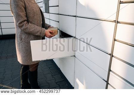 Pickup Parcel. Courier Box In Woman Hands At Post Delivery Automat Terminal. Self Service Post Termi