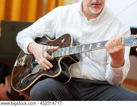 Detail of a guitarist playing an archtop guitar