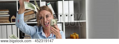 Portrait Of Happy Young Woman Rolling In Money, Flying Cash In Air, Abundance Of Banknotes. Office W