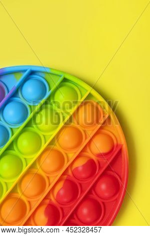 Popular Silicone Multi-colored Anti-stress Toy Pop It On Yellow Background Flat Lay Top View Close-u