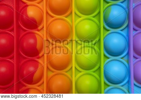 Popular Silicone Multi-colored Anti-stress Toy Pop It Top View Close-up. Trendy Modern Sensory Child