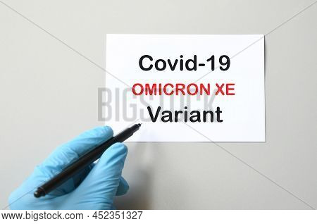 Covid-19 New Omicron Xe. Hand Of The Doctor In Blue Glove With Marker And Writing 