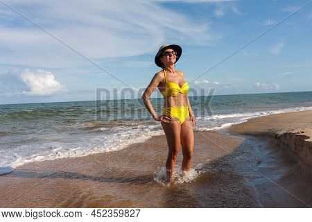 Fit Women In A Yellow Bikini At The Beach Known As Pitinga, In Arraial D\' Ajuda, Bahia, Brazil