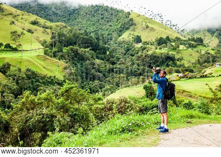 Tourist Taking Pictures At The Beautiful Valle De Cocora Located In Salento At The Quindio Region In