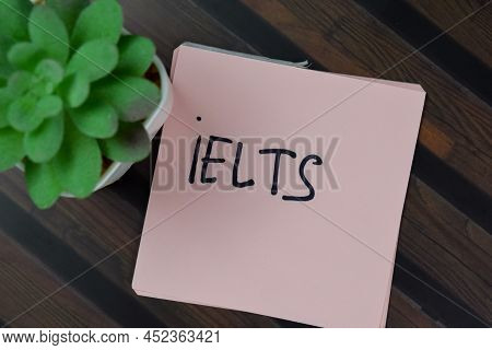 Ielts Write On Sticky Notes Isolated On Wooden Table.