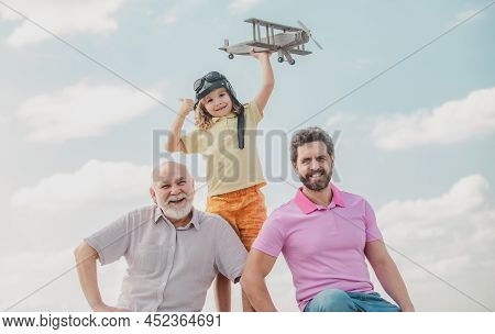 Three Generations Of Men Together, Portrait Of Smiling Son, Father And Grandfather With A Toy Airpla