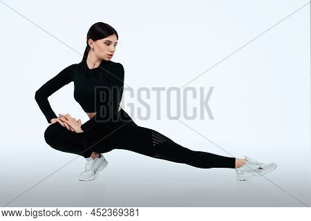 Fitness Woman Doing Half Split Exercises On Workout. Isolated On Gray Background