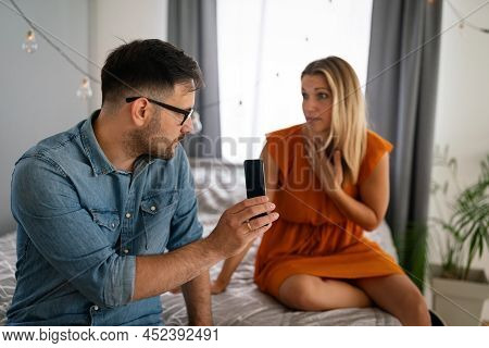 Young Couple With Smartphone Having Quarell And Marriage Conflict Because Of Cheating