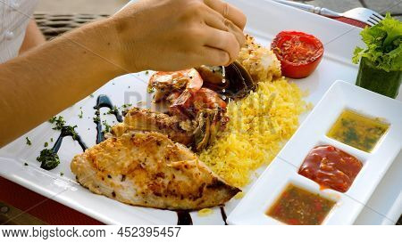 Chef Hand Squeeze Lemon Juice To Seafood Platter With Charcoal Grilled Shrimps, Mussels And Fish Fil
