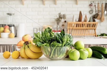 Close Up Of Table With Green Vegetables And Fresh Fruit In The Kitchen