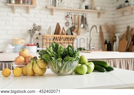 Close Up Of Table With Green Vegetables And Fresh Fruit In The Kitchen