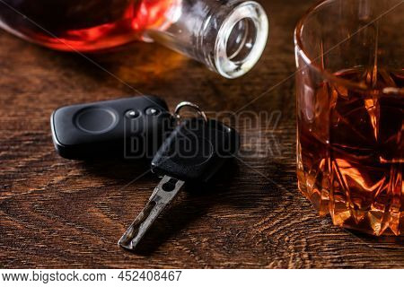 Alcoholic Drink In A Glass And Car Keys On A Wooden Desk. Drunk Driving Concept
