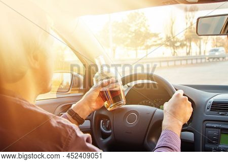 Man Drinking Alcohol While Driving In His Car On Sunset.