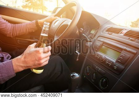 Man Drinking Alcohol While Driving In His Car On Sunset.