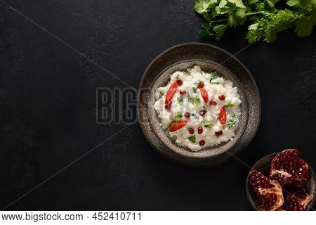 Curd Rice With Pomegranate, Cilantro, Mustard Seeds, Ginger On A Black Background. Indian Cuisine