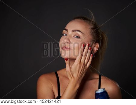 Charming Beautiful Young Woman Using Moisturizer Cream Or Lotions To Enhance The Appearance Of Her F