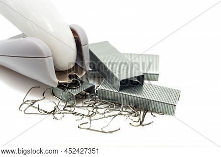 Anti-stapler With Clerical Staples On A White Background. Stationery. Stapler