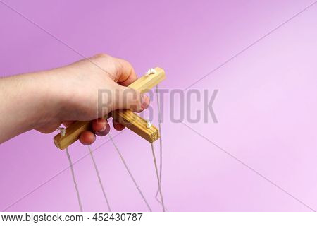 Hand Holds A D-pad With Ropes To Control The Puppet Puppet.