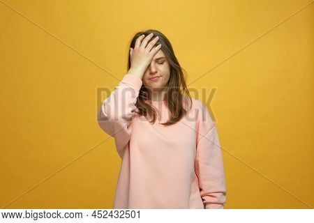 Facepalm Gesture. Young Girl Holding Hand On Face, Feeling Sorrow About Failure, Mistake On Yellow S