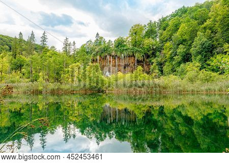Veliki Prstavac Waterfall Reflected In The Potok Plitvice Lake Of Plitvice National Park In Croatia.