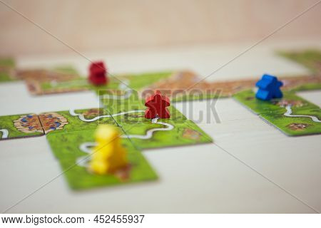 Petrozavodsk, Russia, April 2022: Carcassonne Board Game, Game Cards And Colored Chips On Wooden Tab