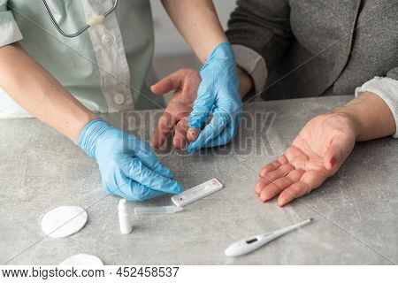 Close Up Female Doctors Hands In White Coat And Medical Gloves Holding Test Tube For Testing In Hema