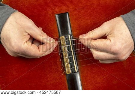 Replacement And Insertion Of Nylon Strings In A Classical Guitar. Lesson For A Musician