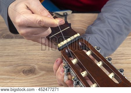 Replacement And Insertion Of Nylon Strings In A Classical Guitar. Lesson For A Musician
