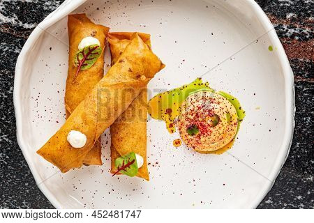 Deep fried popiah popia roll wraps with dipping sauce.