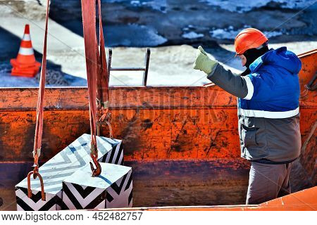 Working Slinger Loads Blocks Or Loads Into Back Of Truck. Slinger Operates Outside On Winter Day. Re