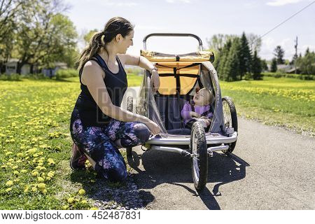 Beautiful Young Family With Baby In Jogging Stroller Running Outside In Summer Season
