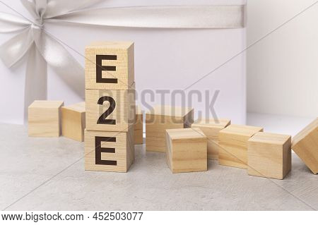 E2e - Letters On Wooden Cubes. Concept On Light Gift Box Background. Business As Usual Concept Image